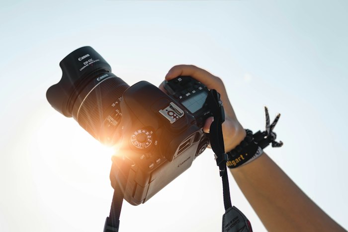 Manos sosteniendo una cámara fotográfica