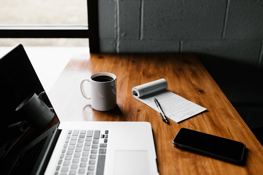 Cuaderno y taza de café sobre una mesa de trabajo